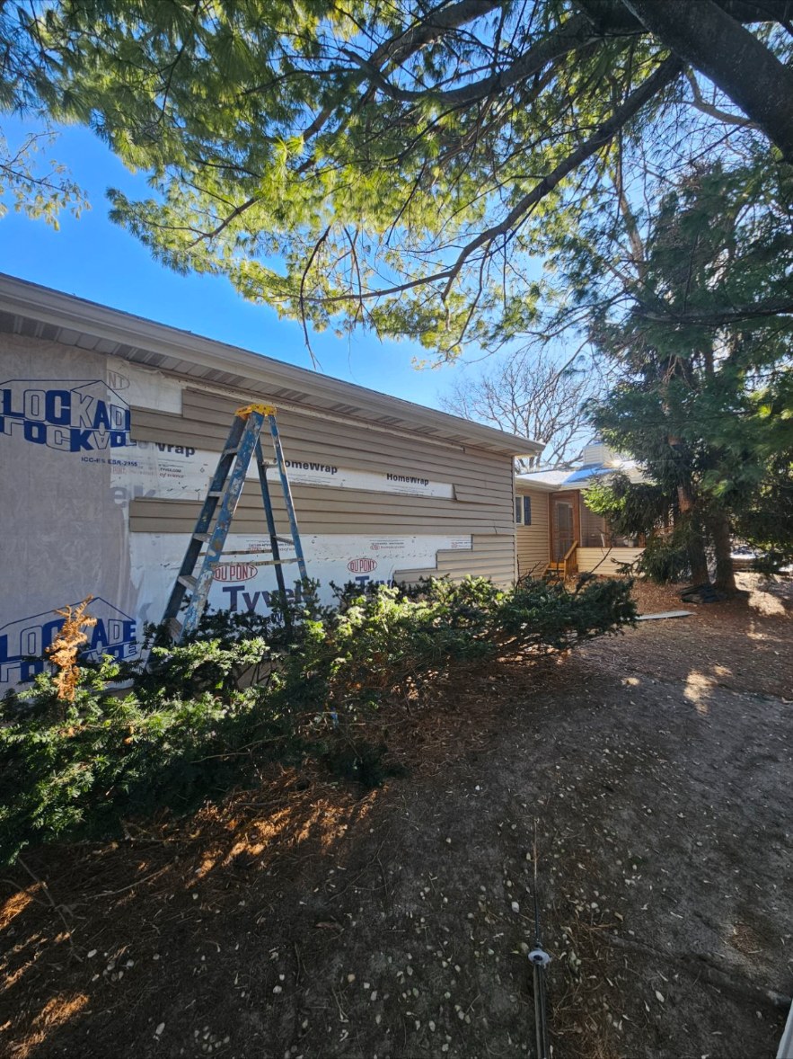 Home with siding torn off down to house wrap before replacement