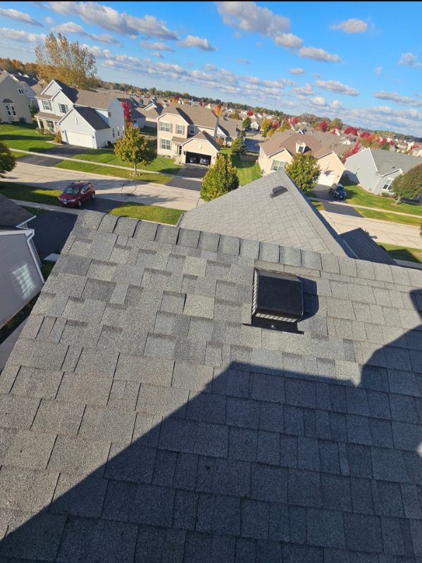 Completed architectural shingle roof on a suburban home